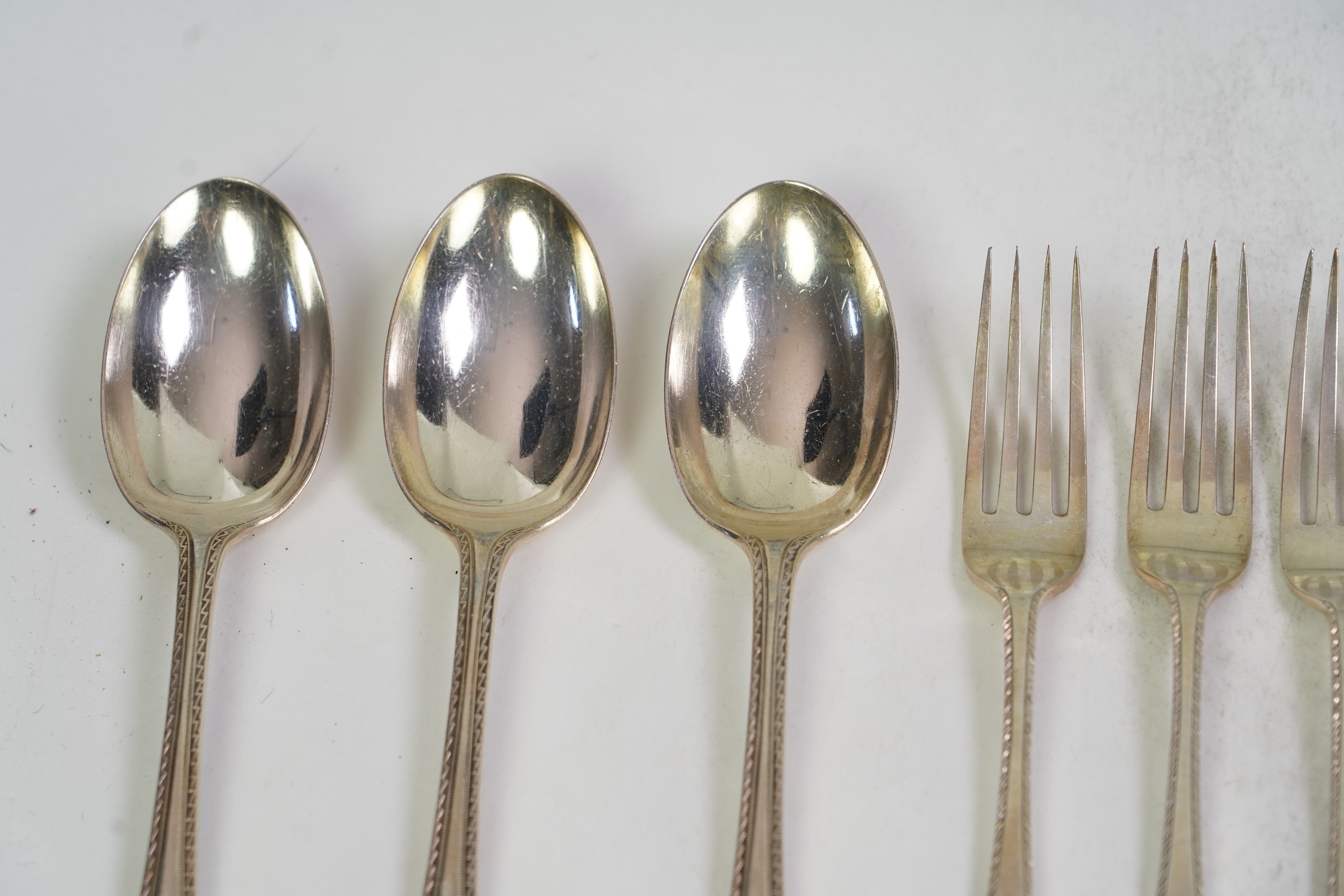 A set of six George V fancy Old English pattern table spoons by Elkington & Co, Birmingham, 1919, 22.2cm, together with a set of six fancy Hanoverian pattern table forks, Goldsmiths & Silversmiths Co Ltd, London, 1918, 3